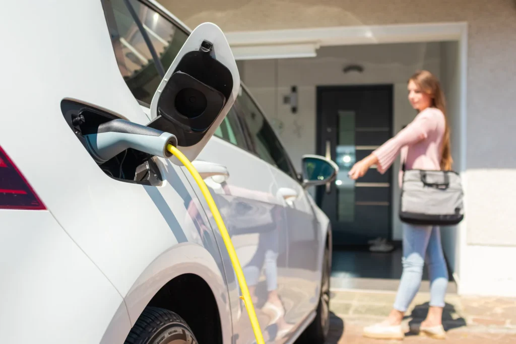 Gebruiker sluit laadkabel aan op een elektrische auto voor een thuisladen sessie.